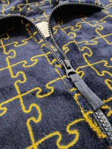 Detalle del cuello camisero de la bata corta Muydemi azul marino con estampado puzzle y líneas mostaza.