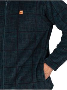 Detalle de la pechera y el bolsillo delantero de la bata corta Massana verde oscuro, con tejido polar y estampado de cuadros difuminados.