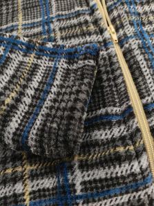 Detalle de la manga y del tejido polar de la bata corta Massana gris con cuadros, perfecta para los días fríos de invierno.